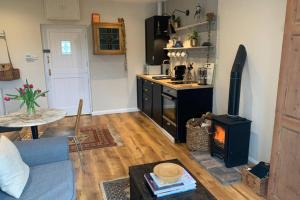 ein Wohnzimmer mit einer Küche mit einem Herd in der Unterkunft The Lambing Shed at Walkmill Farm in Bushmills + 13 Fotos