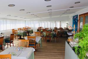 a dining room with tables and chairs in a restaurant at Hotel Europa Milano in Rosate