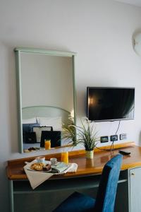 a desk with a plate of food and a mirror at Hotel Europa Milano in Rosate