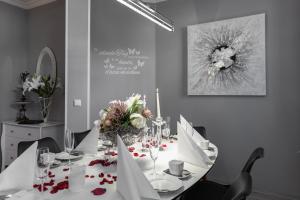 a white table with flowers on it in a dining room at Ferienwohnungen am Wintergarten in Gera