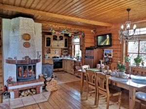 a kitchen with a fireplace and a table and chairs at DvīņuMājas in Balvi