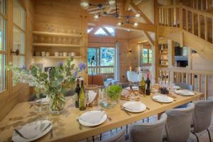 a dining room with a large wooden table and chairs at Chalet Cosyneige - OVO Network in La Clusaz