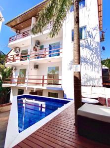 a house with a swimming pool next to a building at Flats Morro de São Paulo in Morro de São Paulo