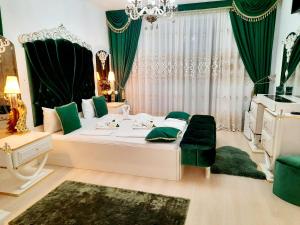 ein Schlafzimmer mit einem großen weißen Bett mit grünen Akzenten in der Unterkunft Hotel Dalia - Bankya in Bankja