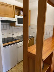 a kitchen with a stove and a microwave at Parenthèse à la montagne in Bessans