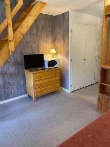 een kamer met een bureau, een tv en een magnetron bij Parenthèse à la montagne in Bessans