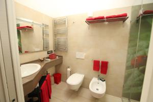 een badkamer met een toilet, een wastafel en een spiegel bij Ai Santi B&B in Dossobuono