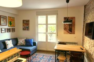 洛格羅尼奧的住宿－Casa Eladia，客厅配有蓝色的沙发和桌子