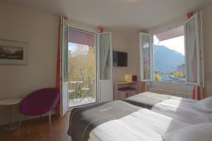 a bedroom with a bed and a large window at Boutique Hotel Bellevue in Interlaken