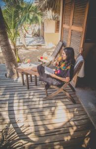 
a young girl sitting on a wooden bench at Un Sueño Cabañas del Pacífico in San Agustinillo
