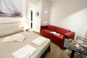 a living room with a red couch and a table at Gaslini e Sole in Genova