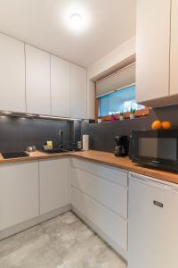uma cozinha com armários brancos e um micro-ondas em Apartament Magnezja Zakopane em Zakopane