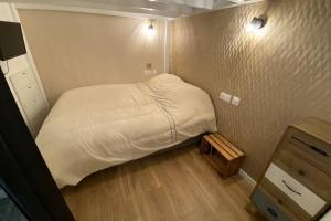 a small bedroom with a bed and a wooden floor at Le Plongeoir de Bon-Secours in Saint Malo