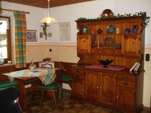 Rottau的住宿－Weissenhof，厨房配有桌子和木制橱柜。