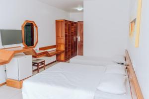 a bedroom with a bed and a desk and a mirror at Poty Praia Hotel in Porto Seguro