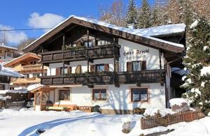 un gran edificio blanco con nieve en el suelo en Gästehaus Friedl, en Kirchberg in Tirol