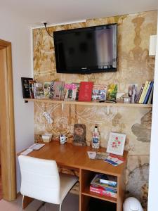 a desk with a chair and a television on a wall at Apartman Danijel Jagic in Petrinja