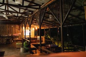 a room with wooden ceilings and a table and chairs at Hostel Plinio in Manuel Antonio