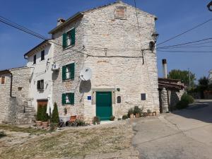 an old stone building with a green door at Casa Porta Verde in Bale