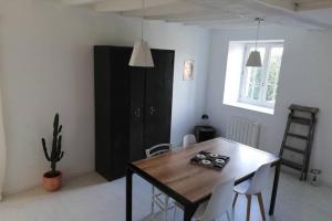 una sala da pranzo con tavolo e sedie in legno di Maison de bourg avec beaucoup de charme a Nuillé-sur-Vicoin