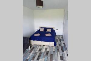 una camera da letto con un letto con un piumone blu di Maison de bourg avec beaucoup de charme a Nuillé-sur-Vicoin