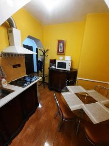 a kitchen with a stove and a table with chairs at Republicii Apartment in Braşov