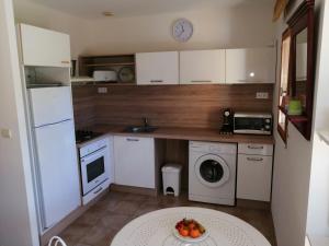 una pequeña cocina con electrodomésticos blancos y una bandeja de fruta en una mesa. en Maison Alba Rossa 56 en Serra-di-Ferro