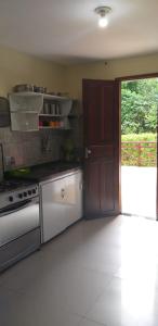 eine Küche mit einem Herd und einer Tür darin in der Unterkunft Casa da Socorro - Serra de Guaramiranga in Pacoti