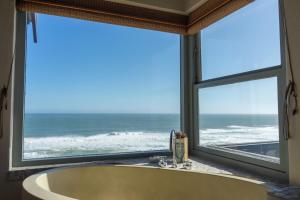 a large window overlooking a beach with a view of the ocean at Dover on Sea B&B in Sedgefield