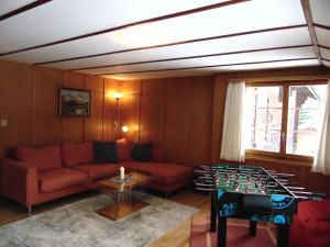 a living room with a couch and a foosball at Ferienwohnung Casa Plauns-iu in Sedrun