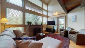 a living room with a couch and a fireplace at Elegant Ski In Ski Out Condo by Harmony Whistler in Whistler