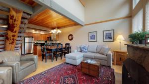 a living room with a couch and a table at Elegant Ski In Ski Out Condo by Harmony Whistler in Whistler