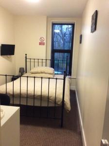 1 dormitorio con 1 cama y ventana en una habitación en Kings arms hotel en Farnworth