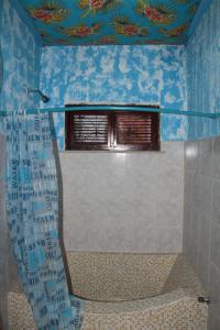 a bathroom with a shower with a toilet and a window at Hostel 35 in Canoa Quebrada