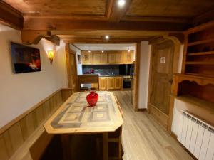 a kitchen with a wooden table with a vase on it at Appartement à Courchevel Saint Bon in Saint-Bon-Tarentaise +11 photos