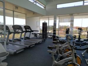 a gym with several tread machines and windows at Departamento Laguna Bahía 808 Velero in Algarrobo