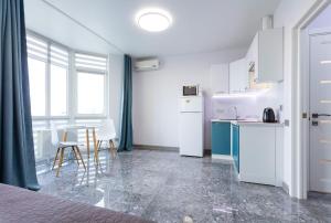 基輔的住宿－Апартаменти "Kopernik"，一间厨房,配有白色家电和桌椅