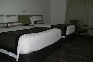a hotel room with two beds and two lamps at Springs Mittagong in Mittagong