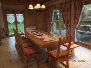 Le Chalet du Pont des Fées - Sauna & SPA في جوراردُميه: غرفة طعام مع طاولة وكراسي خشبية