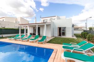 a villa with a swimming pool and lounge chairs at Villa 300m from Beach in Albufeira