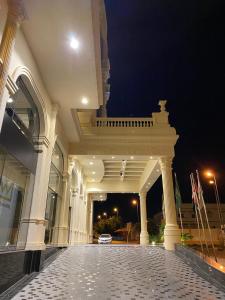 a large white building with a balcony at night at Al Wadaq Hotel in Taif