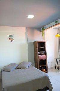 a bedroom with a bed and a book shelf at Meu Apê Maringá - UEM - Perto de tudo! in Maringá