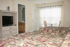 a bedroom with a bed and a television and a table at 2609L home in Calabash