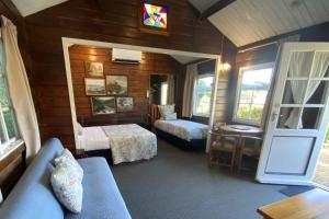 1 dormitorio con sofá, cama y ventana en Paihia Place Cottage - central Paihia, en Paihia