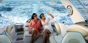 dos mujeres sentadas en la parte trasera de un barco en Suites Canto dos Passaros, en Ilhabela