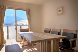a room with a table and chairs and a mountain at Villas Asama no Iori in Fujiyoshida