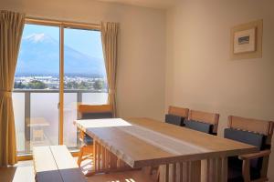 a room with a table and chairs and a large window at Villas Asama no Iori in Fujiyoshida
