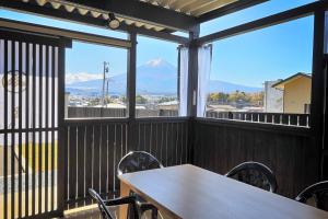 a table and chairs on a balcony with a view of a mountain at Villas Asama no Iori in Fujiyoshida