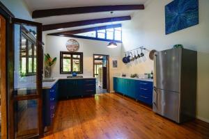 a kitchen with blue cabinets and a stainless steel refrigerator at Wildwood in Cape Tribulation