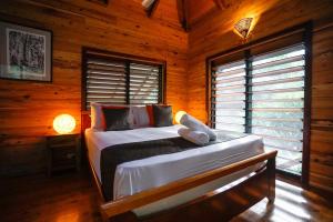a bedroom with a bed in a log cabin at Wildwood in Cape Tribulation